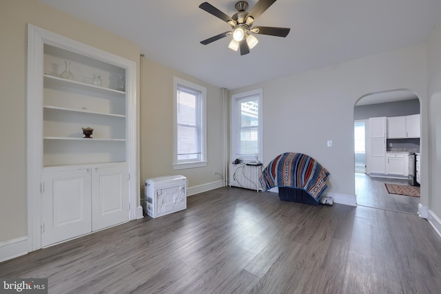 unfurnished living room with dark hardwood / wood-style flooring and ceiling fan