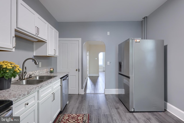 kitchen featuring sink, appliances with stainless steel finishes, white cabinets, and light hardwood / wood-style floors