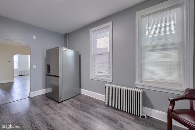 interior space with hardwood / wood-style floors and radiator heating unit