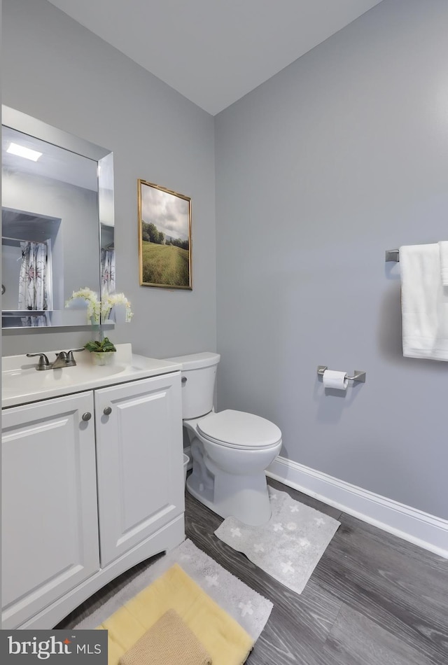 bathroom featuring vanity, toilet, and wood-type flooring