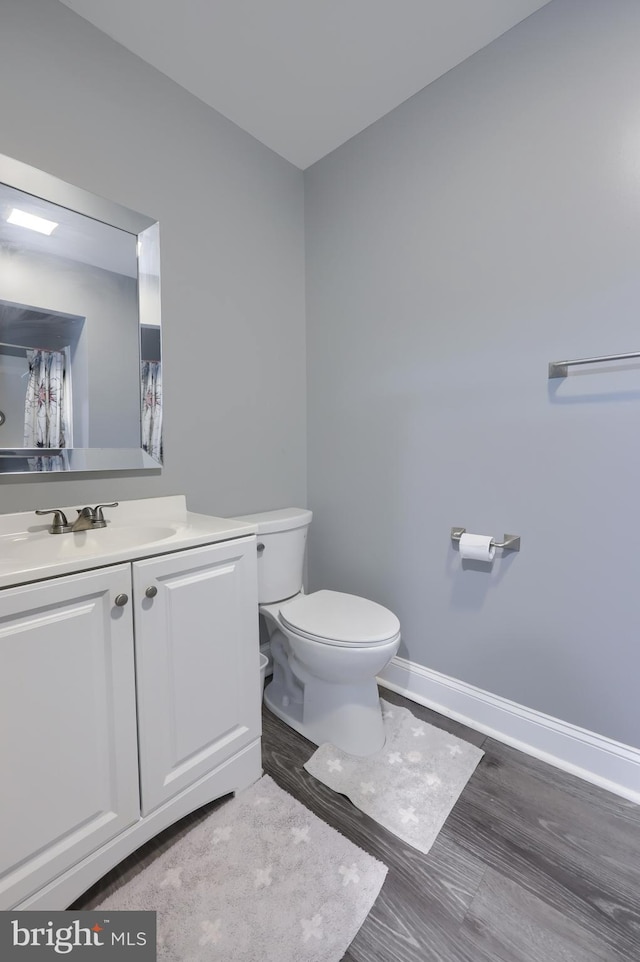 bathroom with vanity, toilet, and wood-type flooring