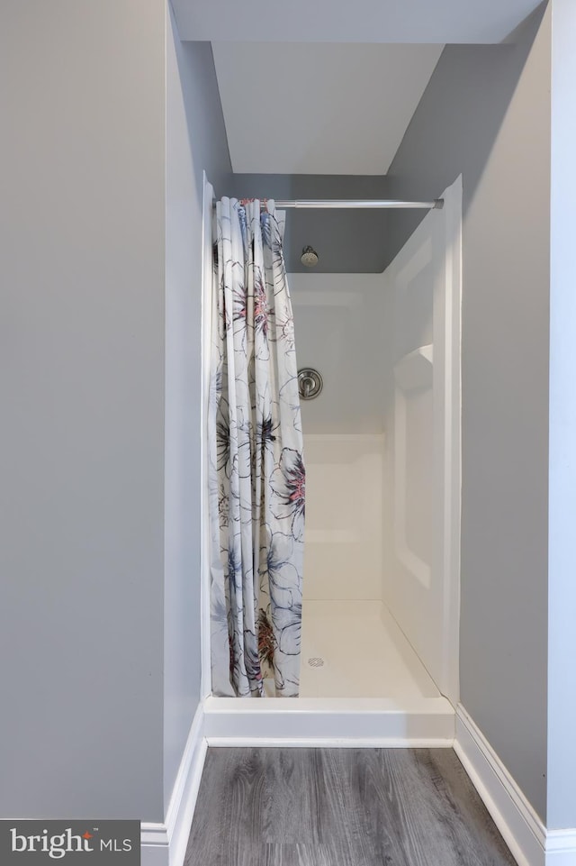 bathroom with a shower with curtain and hardwood / wood-style floors