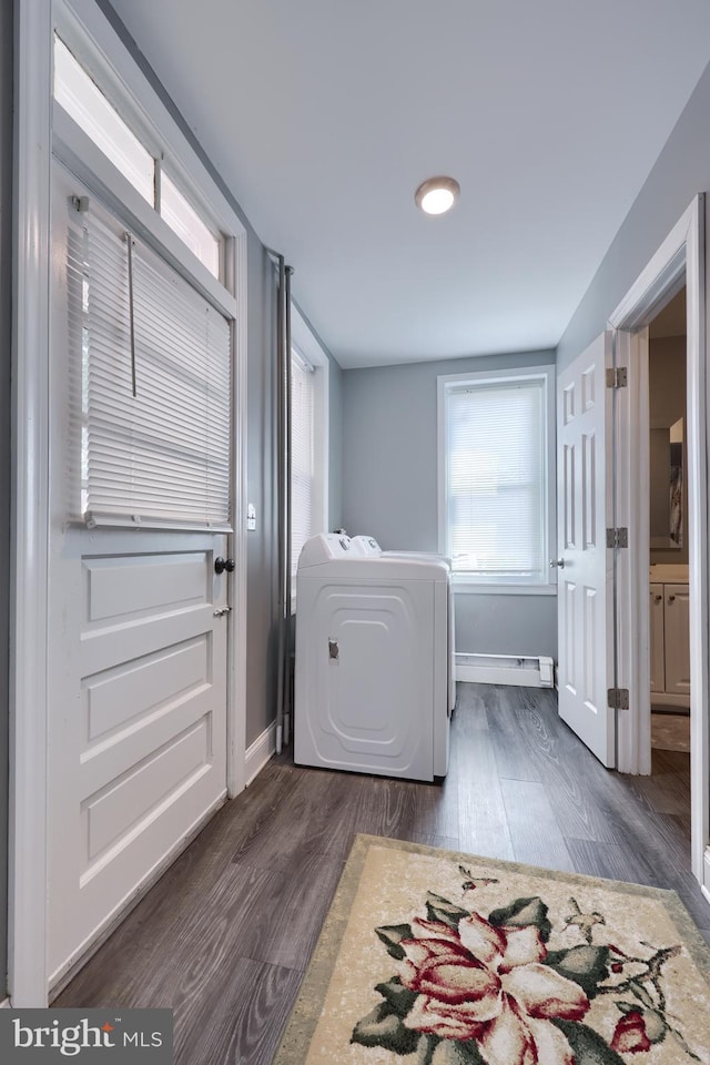 clothes washing area with washer / dryer, dark wood-type flooring, and a baseboard radiator