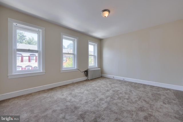 carpeted empty room with radiator heating unit