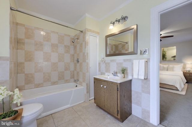 full bathroom featuring tile patterned floors, toilet, tiled shower / bath combo, ceiling fan, and vanity