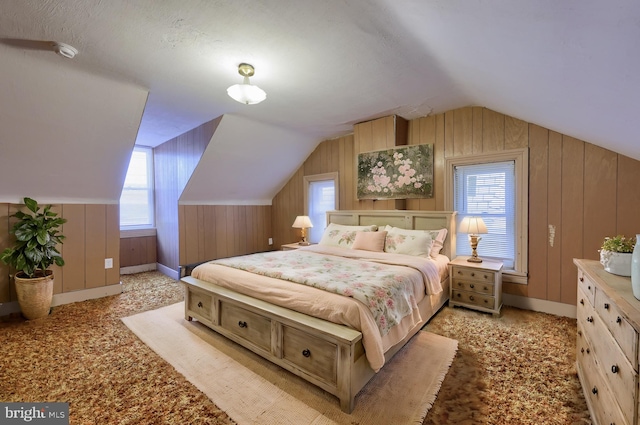 bedroom featuring lofted ceiling, light colored carpet, wooden walls, and a textured ceiling