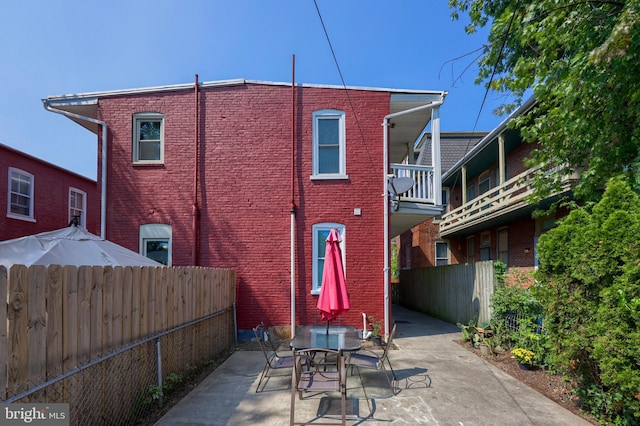 back of property with a balcony and a patio