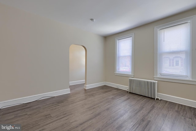 spare room featuring hardwood / wood-style floors and radiator heating unit