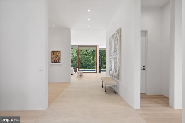 hall with a wall of windows and light hardwood / wood-style flooring