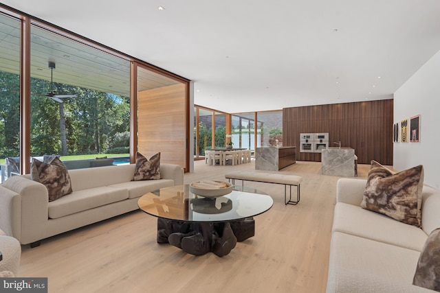 living room with light wood-type flooring and a wall of windows