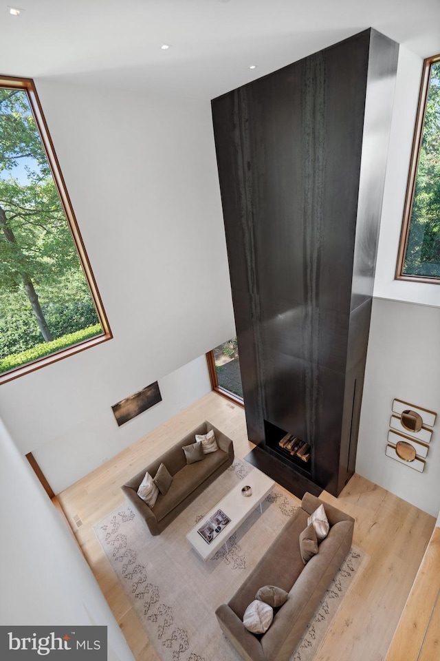 bedroom featuring multiple windows, a fireplace, and light hardwood / wood-style floors