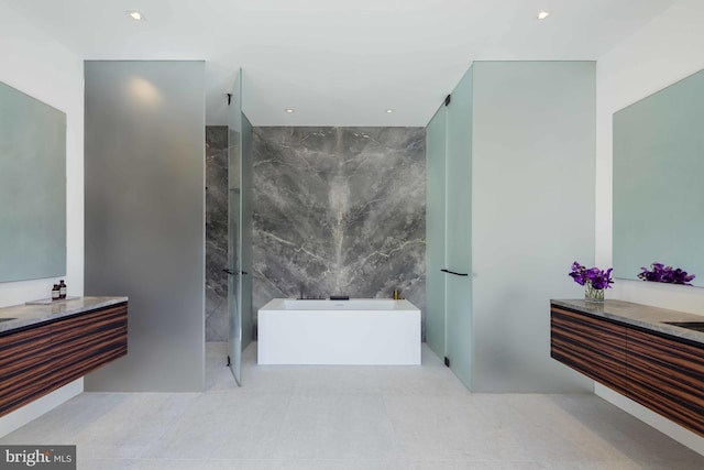 bathroom with tile walls, vanity, and separate shower and tub