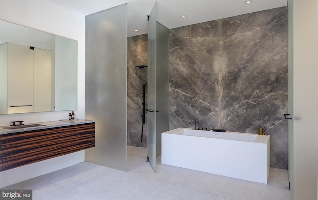 bathroom featuring tile walls, vanity, and separate shower and tub