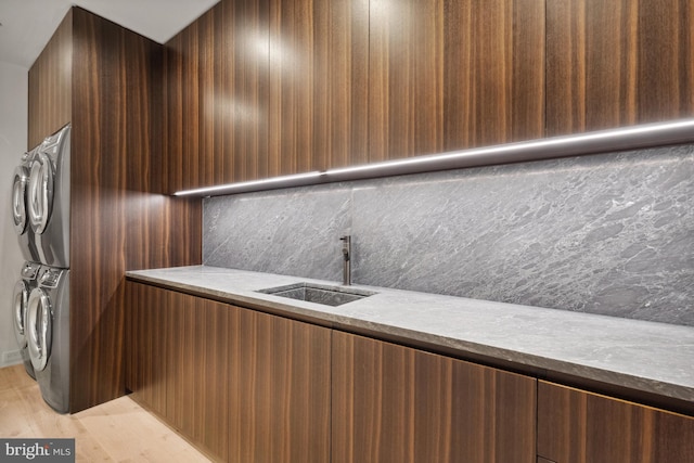 interior space featuring light hardwood / wood-style flooring, sink, and stacked washer and clothes dryer