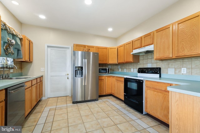 kitchen featuring appliances with stainless steel finishes, decorative backsplash, sink, and light tile patterned floors