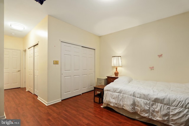 bedroom featuring dark wood-type flooring and multiple closets