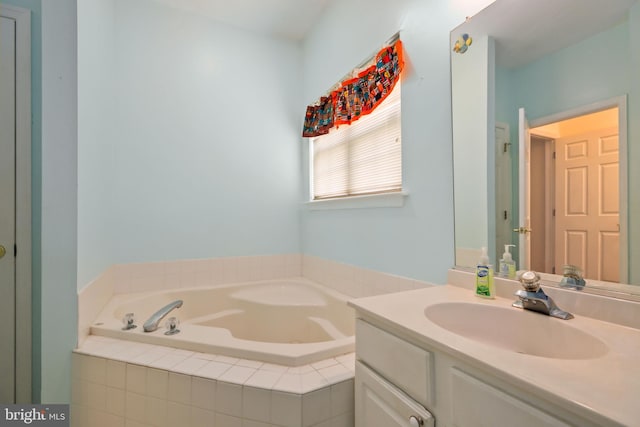 bathroom with a relaxing tiled tub and vanity