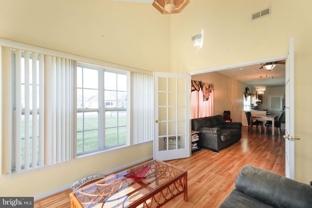 living room featuring french doors, hardwood / wood-style flooring, and a high ceiling