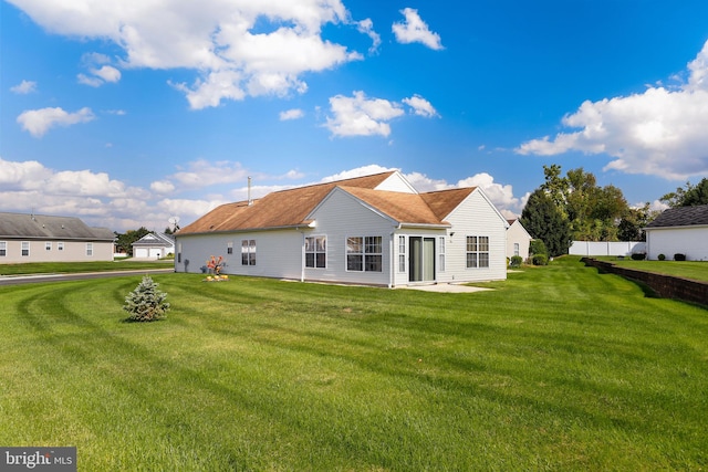 rear view of property featuring a lawn