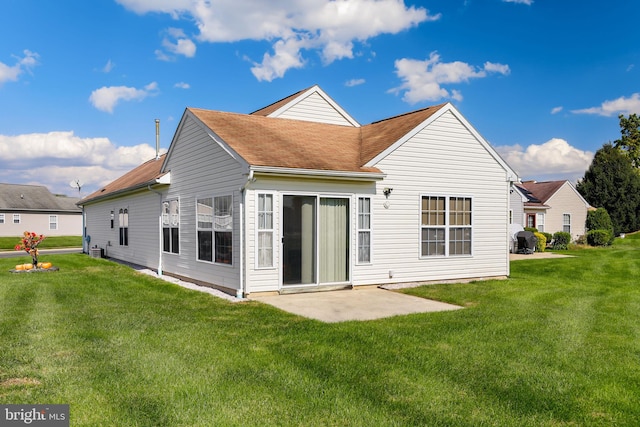 rear view of property with a yard and a patio area