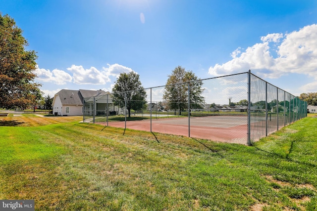 view of tennis court with a lawn