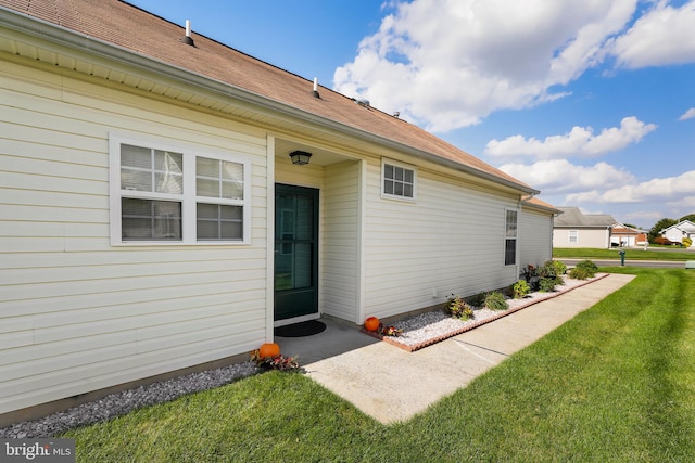 doorway to property featuring a lawn