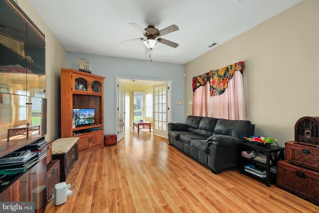 living room with ceiling fan, french doors, light hardwood / wood-style floors, and a healthy amount of sunlight