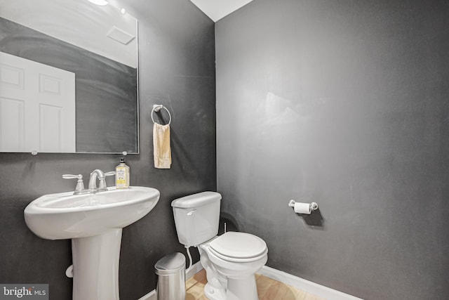 bathroom featuring sink, wood-type flooring, and toilet