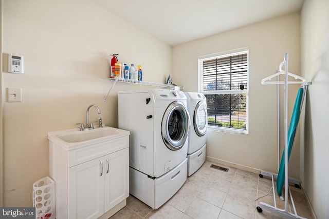 clothes washing area with washer and clothes dryer, light tile patterned floors, and sink