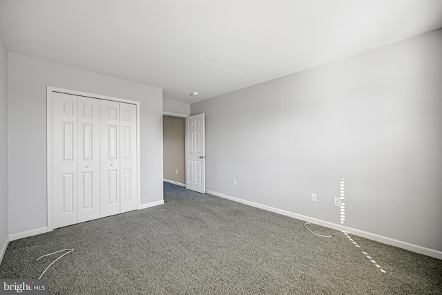 unfurnished bedroom featuring dark colored carpet and a closet