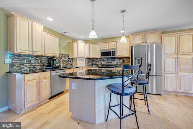 kitchen featuring appliances with stainless steel finishes, light hardwood / wood-style floors, tasteful backsplash, and pendant lighting