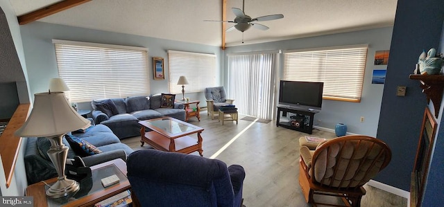 living room with vaulted ceiling with beams, ceiling fan, and light hardwood / wood-style flooring