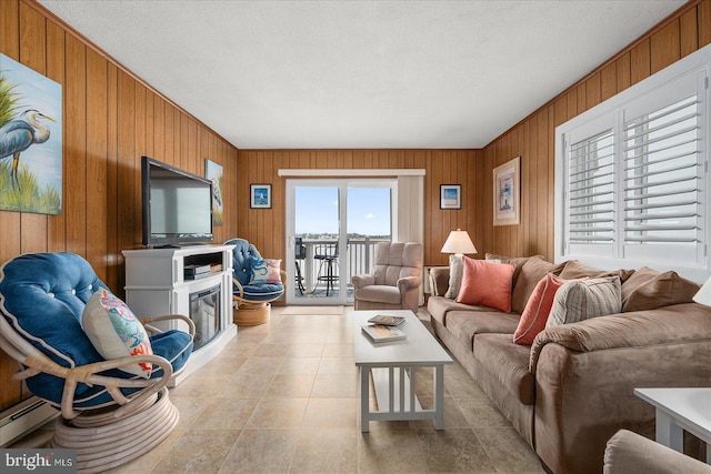 living area featuring light tile patterned floors, a baseboard heating unit, and wood walls