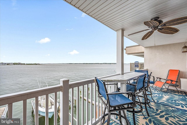 balcony with a water view and a ceiling fan