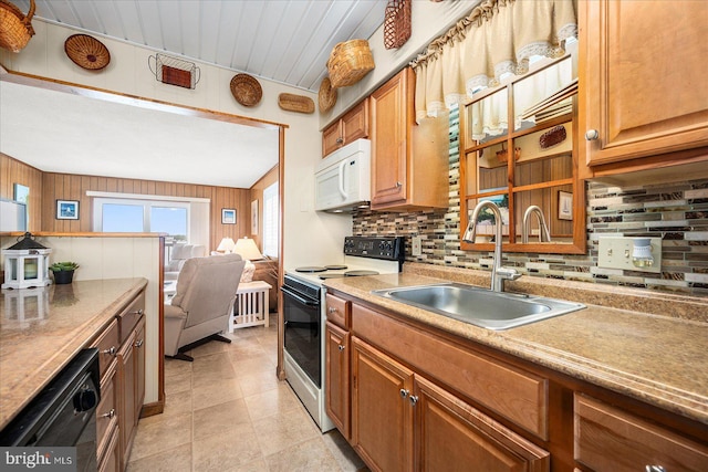 kitchen with white microwave, a sink, black dishwasher, electric stove, and tasteful backsplash