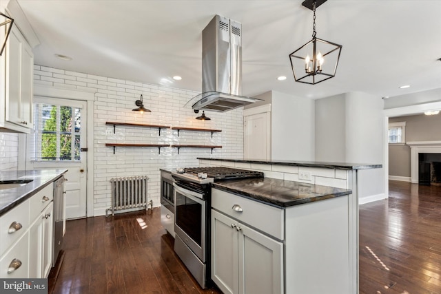 kitchen featuring island range hood, radiator, dark wood-type flooring, stainless steel appliances, and white cabinets