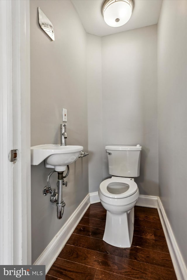 bathroom with hardwood / wood-style floors and toilet