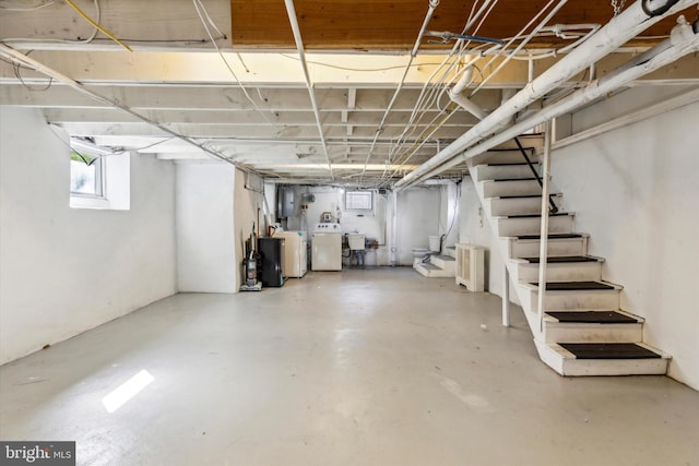 basement featuring sink, washer and dryer, and radiator