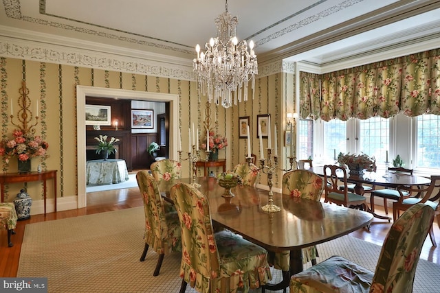 dining area with wallpapered walls, baseboards, a chandelier, and ornamental molding