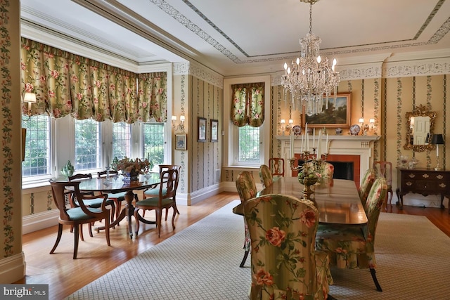 dining room with baseboards, wood finished floors, ornamental molding, and wallpapered walls