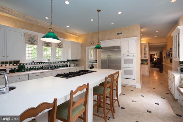 kitchen featuring white appliances, visible vents, light countertops, pendant lighting, and white cabinetry