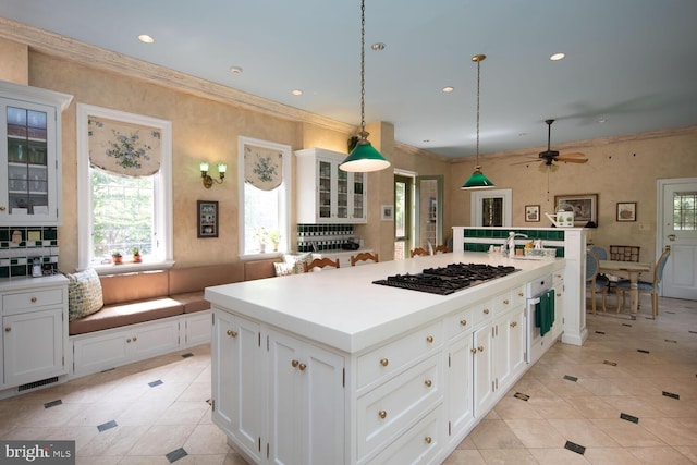 kitchen with white cabinetry, black gas cooktop, glass insert cabinets, and ornamental molding