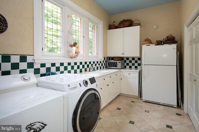 laundry room with a sink, cabinet space, and separate washer and dryer