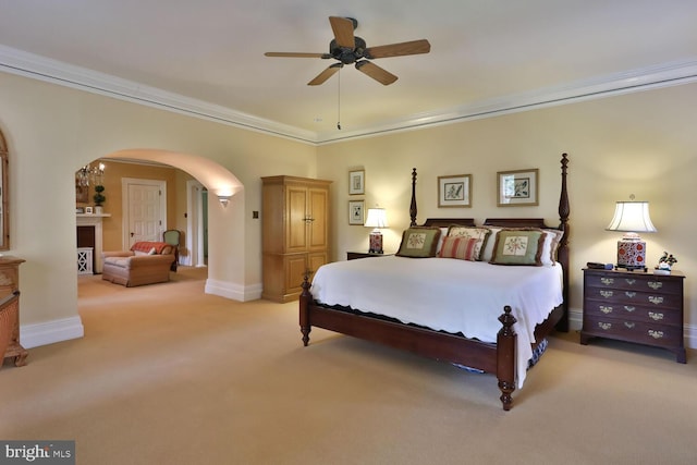 bedroom featuring baseboards, light carpet, arched walkways, and ornamental molding