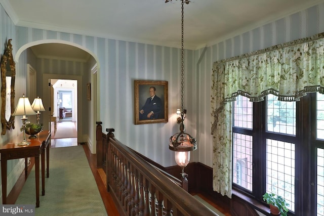 hall with arched walkways and wallpapered walls