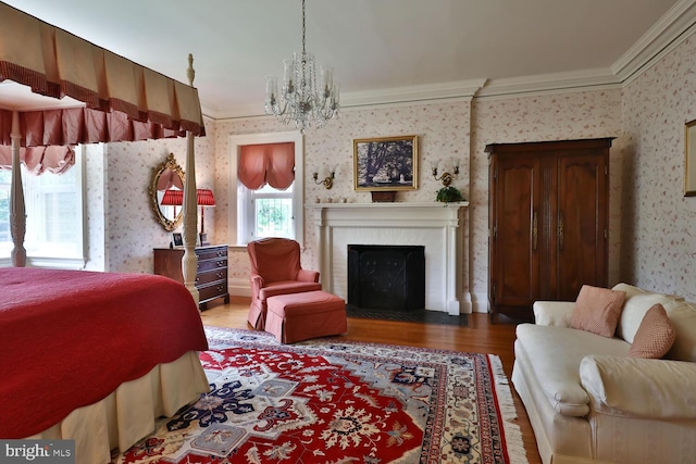 bedroom with a fireplace with flush hearth, wallpapered walls, crown molding, and wood finished floors