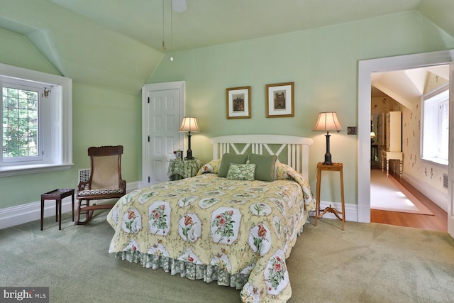 carpeted bedroom featuring vaulted ceiling and baseboards