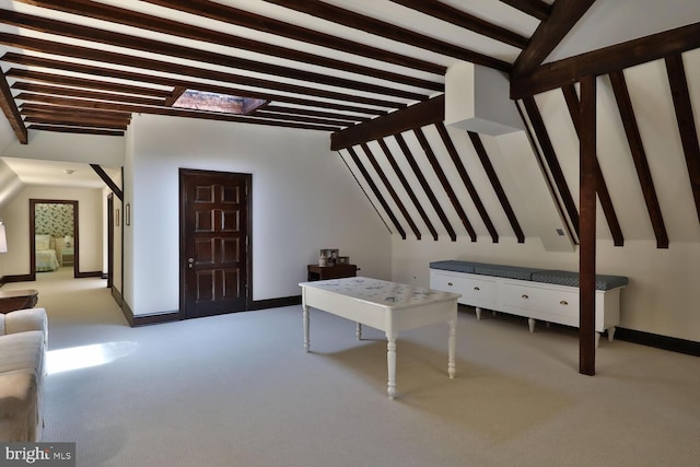 carpeted entrance foyer featuring lofted ceiling with beams and baseboards