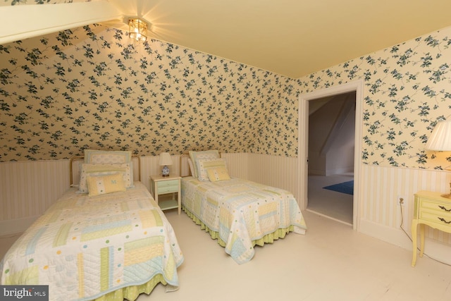 bedroom featuring a wainscoted wall and wallpapered walls