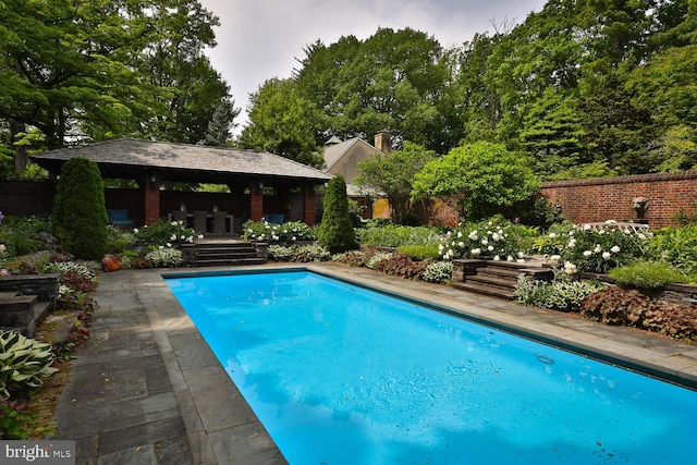 outdoor pool featuring a gazebo and fence